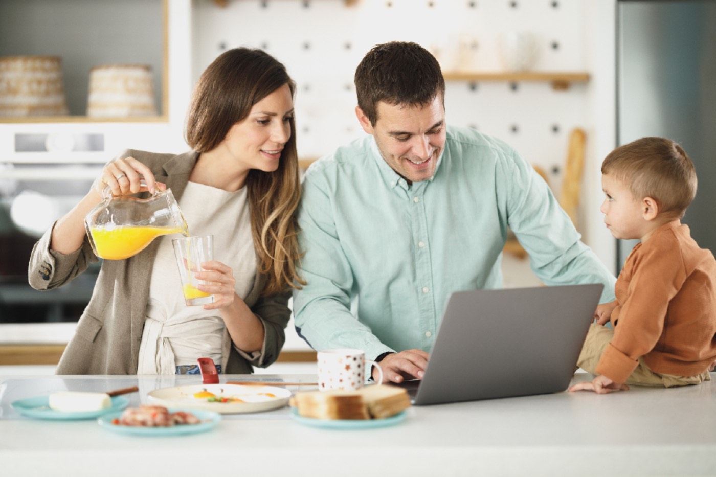 A family at the kitchen table with a laptop